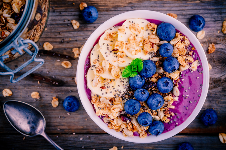healthy smoothie bowl with granola, banana and fresh blueberries