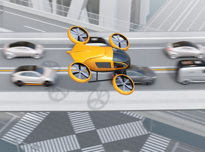 Yellow passenger drone flying over cars in heavy traffic jam