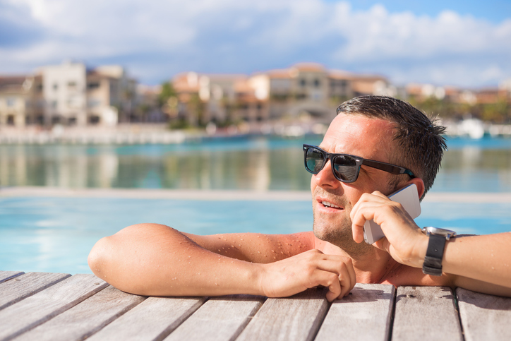 Man talking on phone while relaxing in the pool