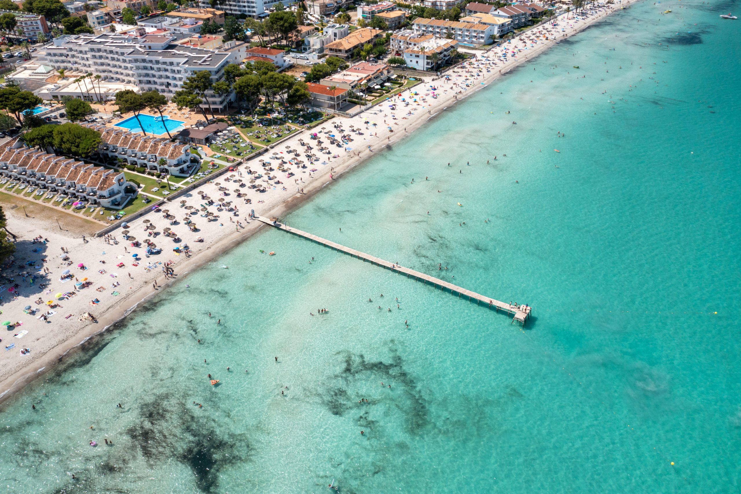 Aerial drone photo of the beach front on the Spanish island Majorca Mallorca, Spain showing the beach known as Platja de Muro in the village of Alcúdia on a sunny summers days